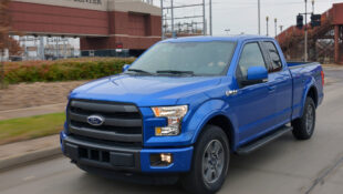 Blue 2015 Ford F-150 Lariat in front of Ford Rogue Center